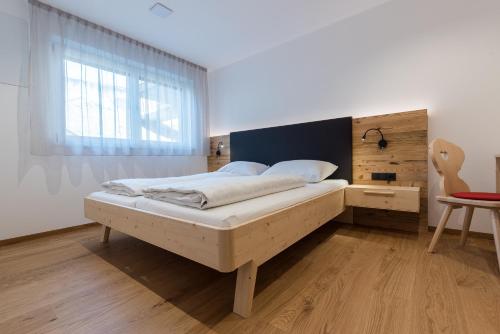 a bedroom with a bed and a window and a table at MESNERHOF CHALET - Ruhe, Rückzug & Südtiroler Charme mit kostenlosem Parken in der Tiefgarage in Bressanone