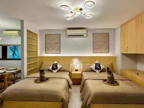 a hotel room with two beds and a table at Pico De Loro 2BR Condo Unit in Nasugbu