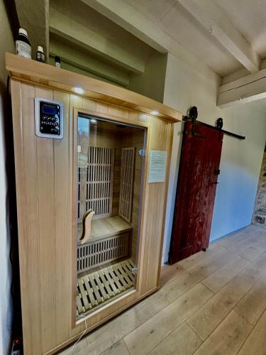 une grande enceinte en bois dans une chambre avec une porte dans l'établissement Fraîcheur garantie château perché avec rivière privée en pleine nature, à Cazenave-Serre-et-Allens