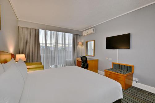a hotel room with a large bed and a television at Holiday Inn - Bulawayo by IHG in Bulawayo
