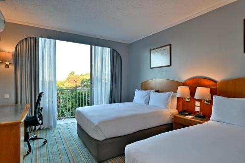 a hotel room with two beds and a window at Holiday Inn - Bulawayo by IHG in Bulawayo