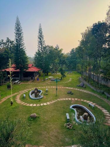 a park with a fountain and a pond at The Temple Tree Residence in Yelagiri