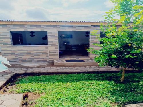 a stone house with a patio and a yard at Glamour Lodges and Apartments in Livingstone