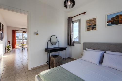 a bedroom with a bed and a desk in it at AVS Margarita Gardens in Paphos City