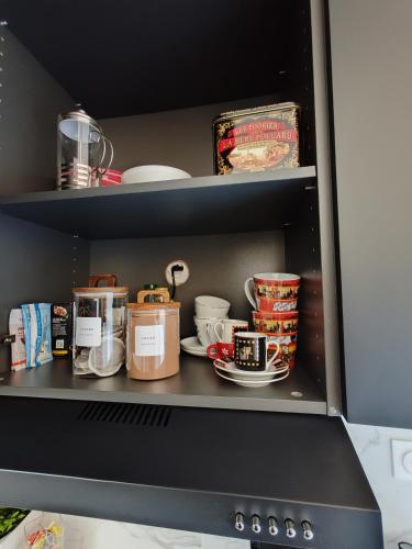 un garde-manger avec une étagère remplie de vaisselle et d'inventaire dans l'établissement Studio 2 pers entièrement équipé, à Prades-le-Lez