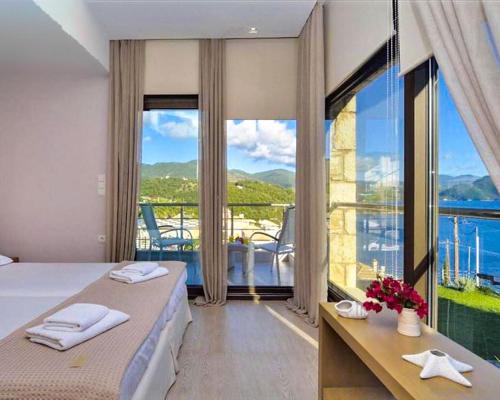 a hotel room with a bed and a large window at Christie's Luxury Suites by Dandy Hospitality in Syvota