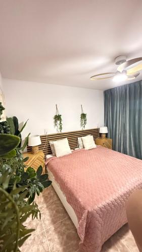 a bedroom with a bed with a pink comforter at Atlantico Flamingo in Calpe