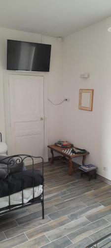 Cette chambre comprend un lit, une table et une porte. dans l'établissement Tandem Anjou Touraine, à Restigné