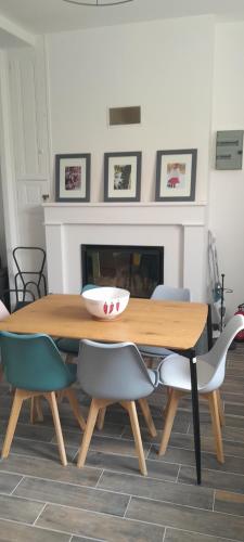 une table de salle à manger avec des chaises et un bol dessus dans l'établissement Tandem Anjou Touraine, à Restigné