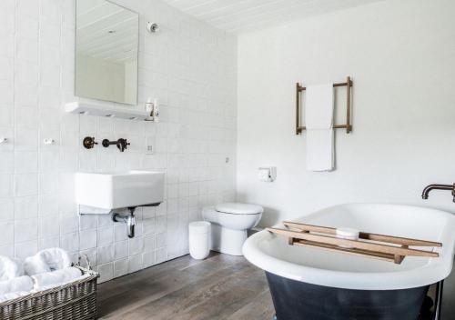 une salle de bain avec une baignoire, des toilettes et un lavabo dans l'établissement River Cottage HQ, à Musbury