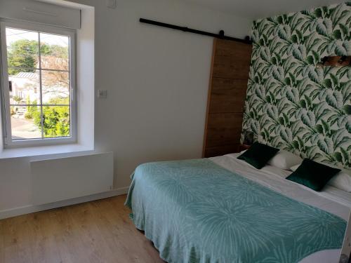 a bedroom with a bed and a window at Chez Henri in Les Herbiers