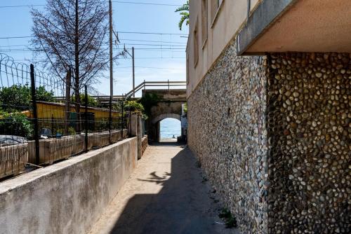 an alley with a stone wall next to a bridge at Pieds dans l'eau Terrace, Spa & Cactus in Bordighera