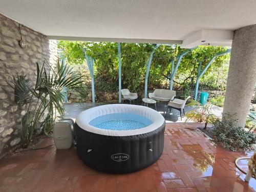 a large hot tub sitting on a patio at Pieds dans l'eau Terrace, Spa & Cactus in Bordighera