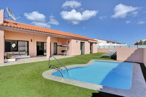 a backyard with a swimming pool and a house at Golden dunes villa picasso in Costa de Antigua