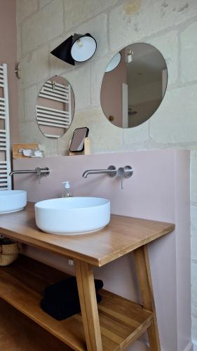 a bathroom with a sink and two mirrors at La Grange in Savonnières