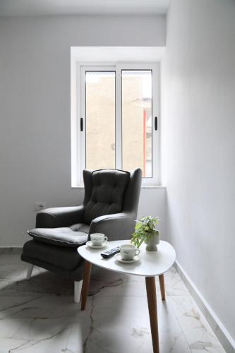 a living room with a chair and a coffee table at Rozafa Guest Room Center in Shkodër