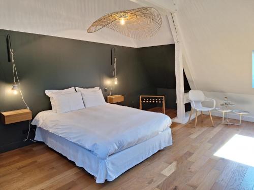 a bedroom with a white bed and a black wall at La Grange in Savonnières