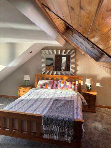 a bedroom with a bed with a wooden headboard at High Tide Beach House on waters edge in Bangor