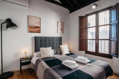 a bedroom with a large bed with towels on it at DreamStay - Oficios Apartamento in Granada