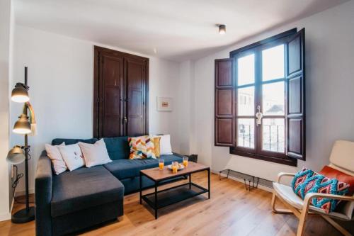 a living room with a blue couch and a table at DreamStay - Oficios Apartamento in Granada