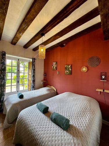 two beds in a room with orange walls at Domaine de la Maroutière in Saint-Fort