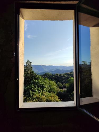 an open window with a view of a forest at Sur la Draille in Le Vigan
