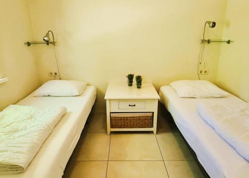 德科赫De Witte Schelp的配有两张床铺的客房设有一张边桌