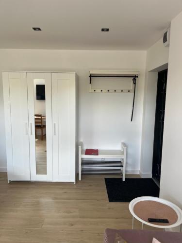 a living room with white cabinets and a table at Apartament Luizy in Człuchów