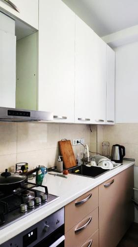 a kitchen with white cabinets and a sink at Lomtadze Family Wine Hotel in Ambrolauri