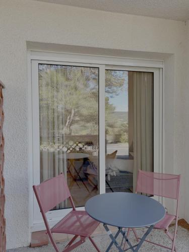 une table et deux chaises roses et une table et un patio dans l'établissement Fairway 4, à Saint-Gély-du-Fesc