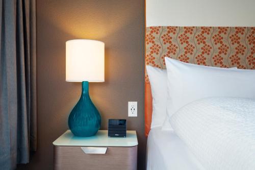 a blue lamp sitting on a nightstand next to a bed at Staypineapple, University Inn, University District Seattle in Seattle