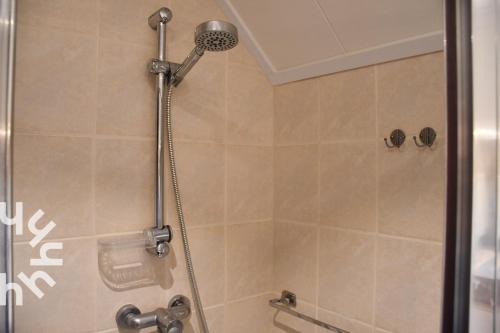 a shower with a shower head in a bathroom at OV606 - Beautifully located 6-person holiday home by the water with a large garden in Ossenzijl in Ossenzijl