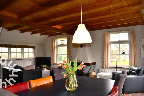 a vase of flowers on a table in a living room at OV606 - Beautifully located 6-person holiday home by the water with a large garden in Ossenzijl in Ossenzijl