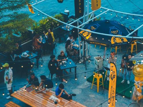 a group of people sitting at tables in a pool at The Royal River Hotel in Bangkok