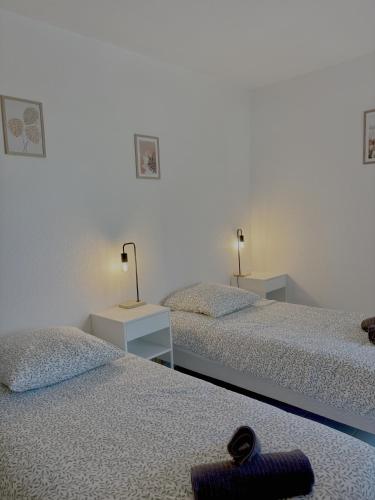 - une chambre avec 2 lits et 2 lampes sur les tables dans l'établissement Fairway 4, à Saint-Gély-du-Fesc