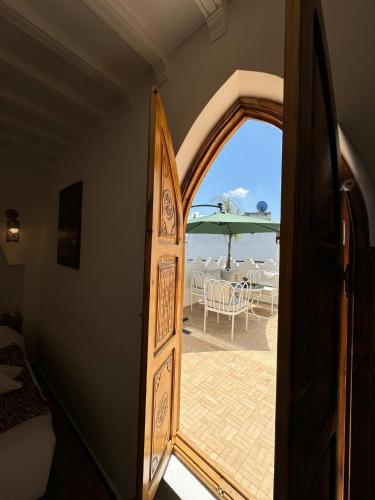 an open door leading to a patio with an umbrella at Kasba Green in Tangier