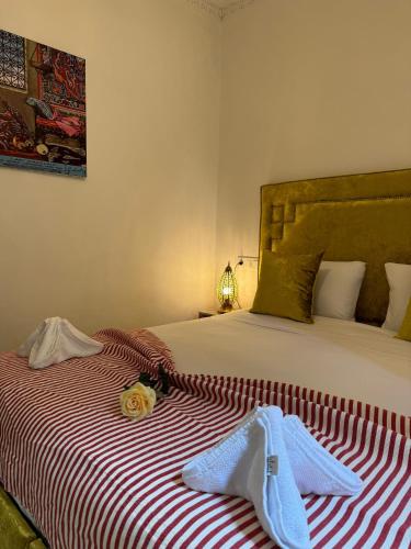 a bed with a red and white striped blanket at Kasba Green in Tangier