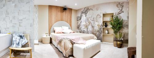 une chambre avec un lit et une chaise dans l'établissement Suites Balneo à Melun by Lilac Lane, à Melun