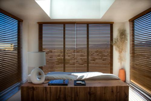 a bedroom with a bed with a wooden table and windows at The Milky Way Cabin in Twentynine Palms