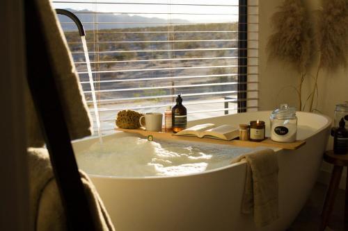 a bathroom with a bath tub with a window at The Milky Way Cabin in Twentynine Palms