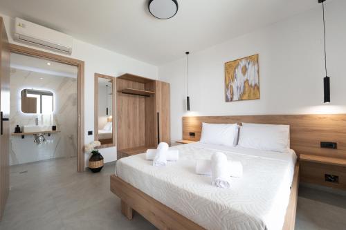 a bedroom with a large white bed with white pillows at Chryselia Suites- Private Pool in Keratokampos