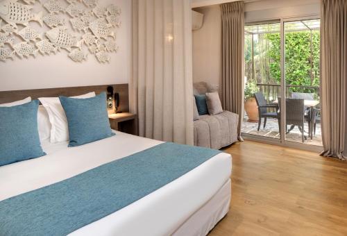a bedroom with a bed and a living room at Le Cottage - Hotel & Spa in Argelès-sur-Mer