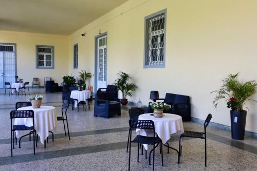 a room with tables and chairs with plants on them at Casa Lux Mundi Lucca in Lucca
