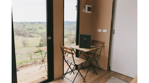 un escritorio con un ordenador portátil junto a una ventana en Rose Hill by Tiny Away, en Neerim South