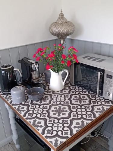 a kitchen counter with a table with flowers on it at Seaview Room at The Boat House in Eastdean