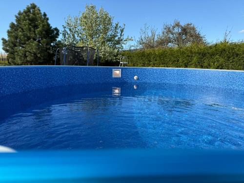 a blue swimming pool with a blue fence at Pension U Babi in Chrášťany