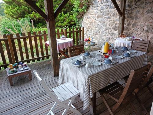 einen Tisch und Stühle auf einer Holzterrasse in der Unterkunft Les Ombelles in Saint-Estèphe