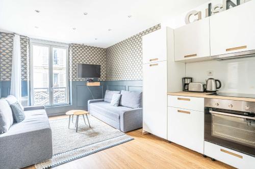un salon avec un canapé et une cuisine dans l'établissement Urban Flat 18 - 2 Bedrooms flat in central Paris, à Paris