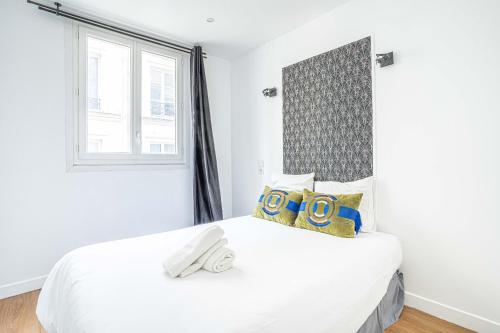 une chambre avec un grand lit blanc et une fenêtre dans l'établissement Urban Flat 18 - 2 Bedrooms flat in central Paris, à Paris