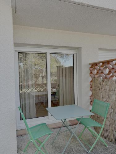 une table et deux chaises sur une terrasse dans l'établissement Loft 4, à Saint-Gély-du-Fesc